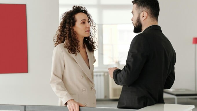 A male and female engage in a workplace conversation
