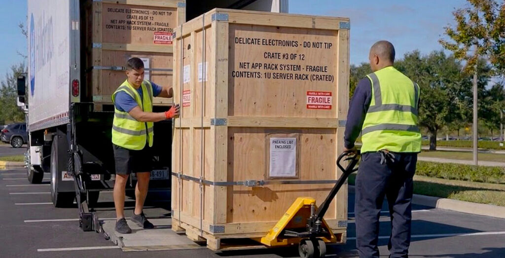 Crew unloading created server racks at a data center site build.