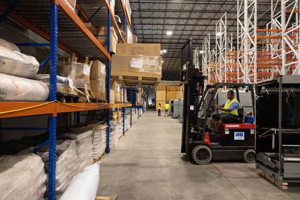 Warehouseman removing pallet from racking with a forklift