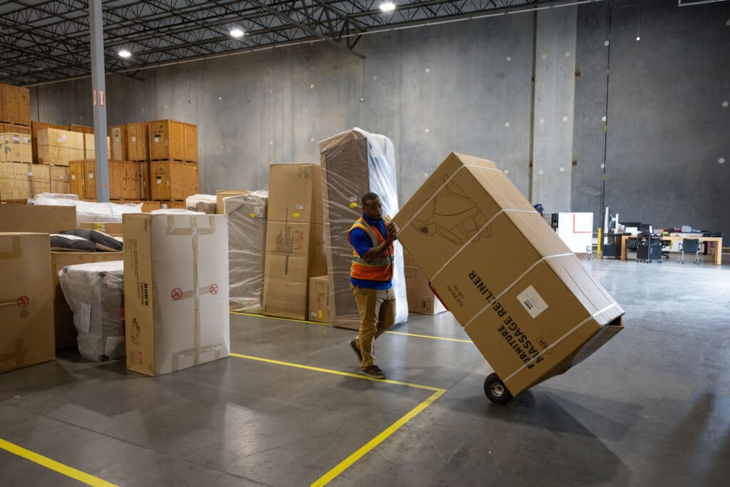 Warehouseman placing large items in staging area